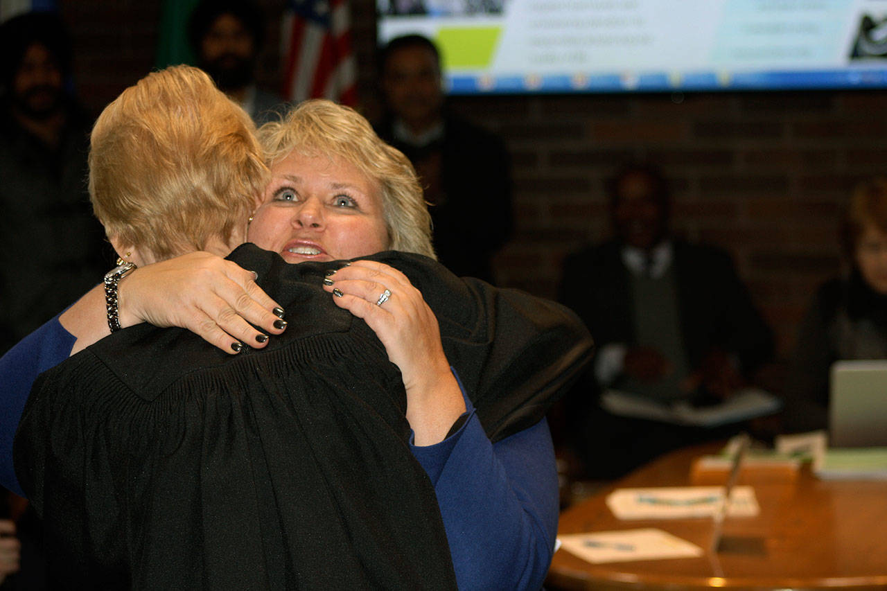 Kent Mayor Dana Ralph receives a congratulatory hug from Kent Municipal Court Judge Karli Kristine Jorgensen Tuesday night after taking her oath of office at City Hall. STEVE HUNTER, Kent Reporter
