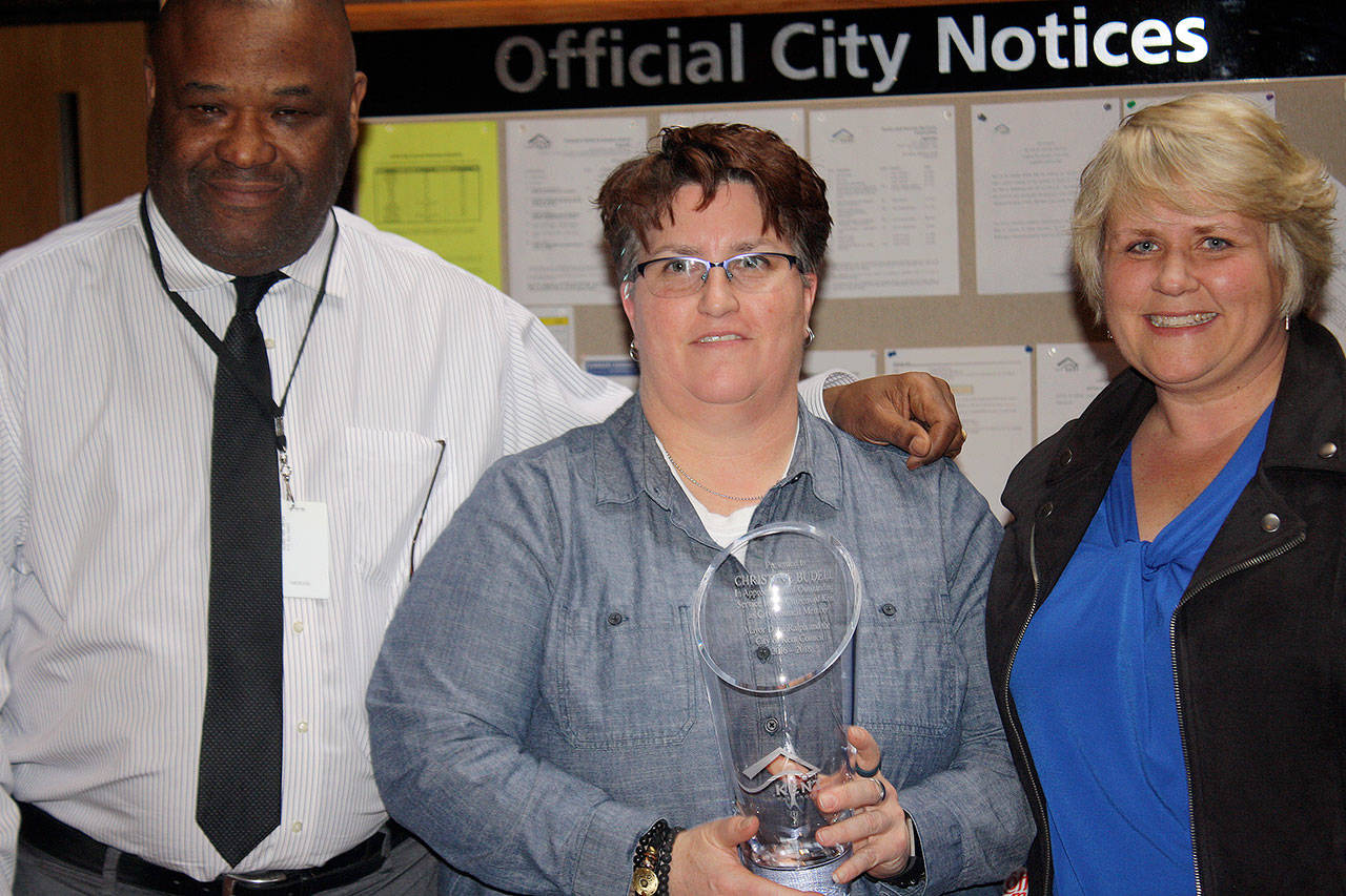 City Council President Bill Boyce, left, and Mayor Dana Ralph, right, honor Tina Budell, center, on Tuesday for her two years on the council. Budell resigned to take a job in Chicago. STEVE HUNTER, Kent Reporter