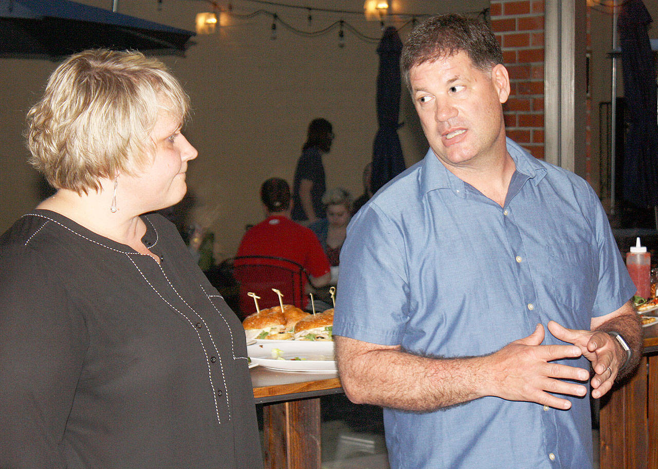 Kent Mayor Dana Ralph, left, and Police Chief Ken Thomas discuss Tuesday night during a gathering at Airways Brewing the rejection by voters of a measure that would have raised utility taxes to pay for more officers. STEVE HUNTER, Kent Reporter