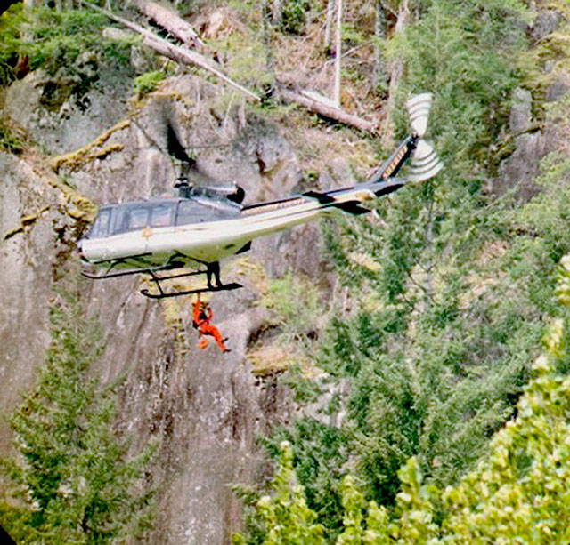 The SnoHAWK10 helicopter of the Snohomish County Sheriffs Office on Saturday lowered a rescue technician and flight medic to treat a man who fell while climbing the Index Town Wall. (Snohomish County Sheriffs Office)