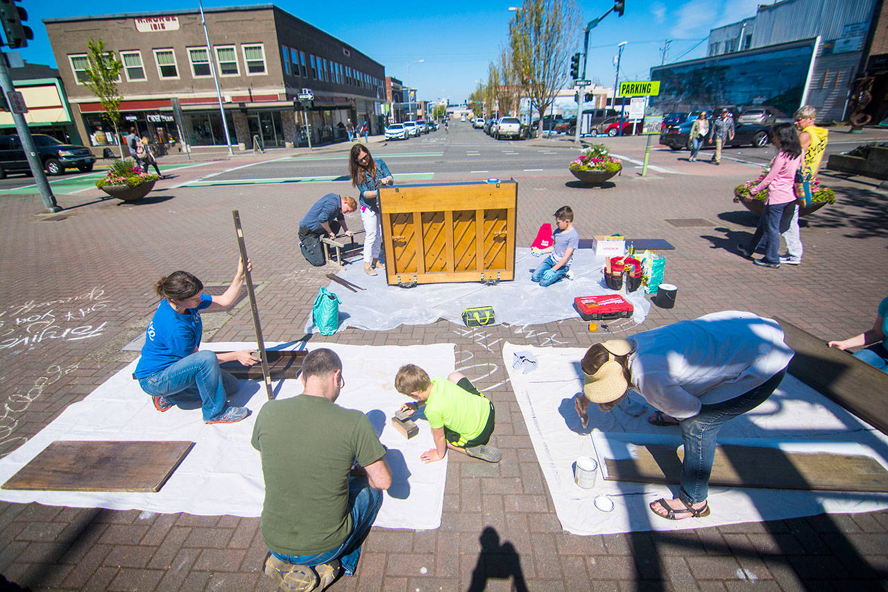 A work party on Saturday prepares Port Angeles’ downtown piano for a makeover on Saturday. (Jesse Major/Peninsula Daily News)
