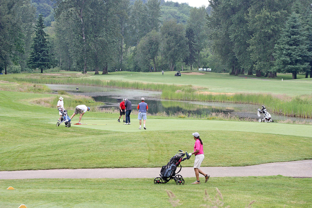Golfers play the 18-hole Riverbend course in Kent. City officials plan major improvements at the course over the next two years. FILE PHOTO