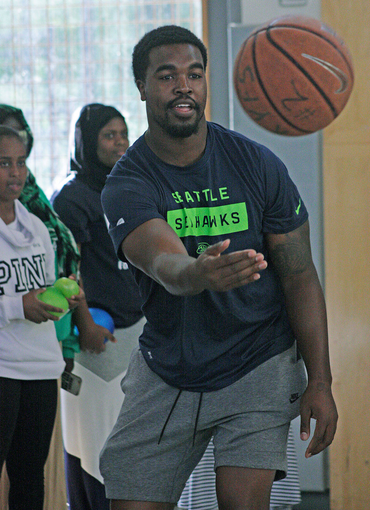 The Seahawks Tyrone Swoopes, a 6-foot-4 tight end, plays basketball with boys and girls during a career fair at the Birch Creek Youth Center. MARK KLAAS, Kent Reporter
