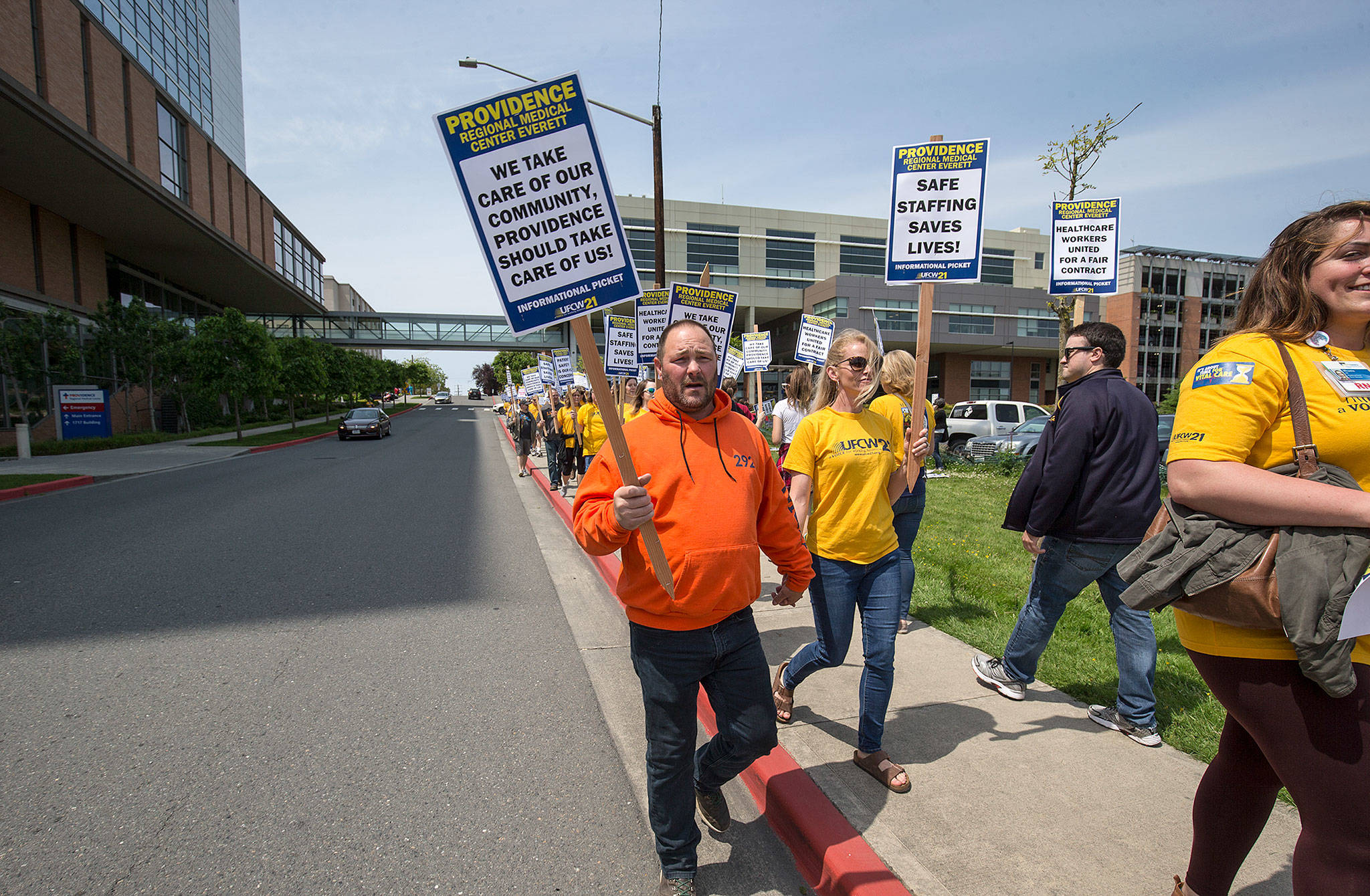 Nurse Katy Roth and her husband, Rod, a union member with Labor Local 292, walk with other nurses on a picket line at Providence Regional Medical Center Everett on Wednesday. (Andy Bronson / The Herald)