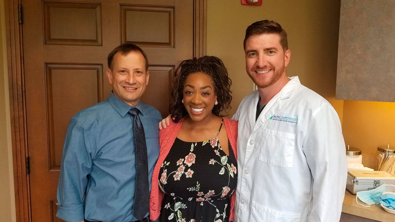 Doctors Cal Broadbent, left, and Ben Johnson, with India Coleman, after her final treatment in the Pacific Northwest Oral & Maxillofacial Surgeons’ Renton office. COURTESY PHOTO