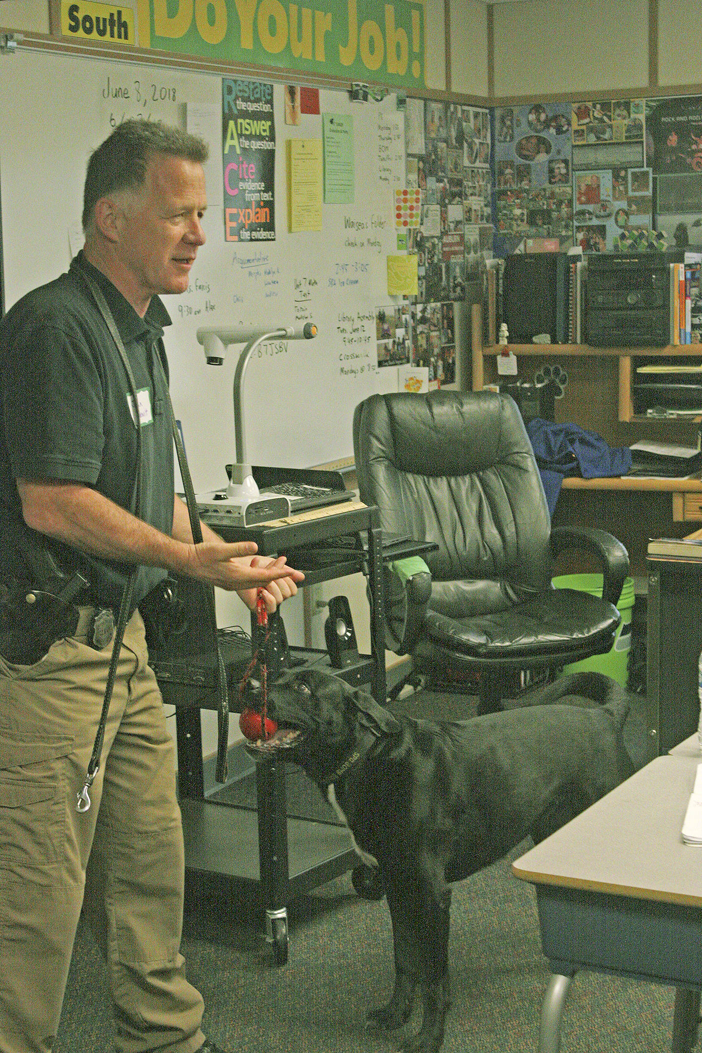 Detective John Lewitt, of the Seattle Police Department’s arson/bomb squad, introduces Boomer to students in Jesse Merry’s sixth grade class during career day at Meridian Elementary School. MARK KLAAS, Kent Reporter