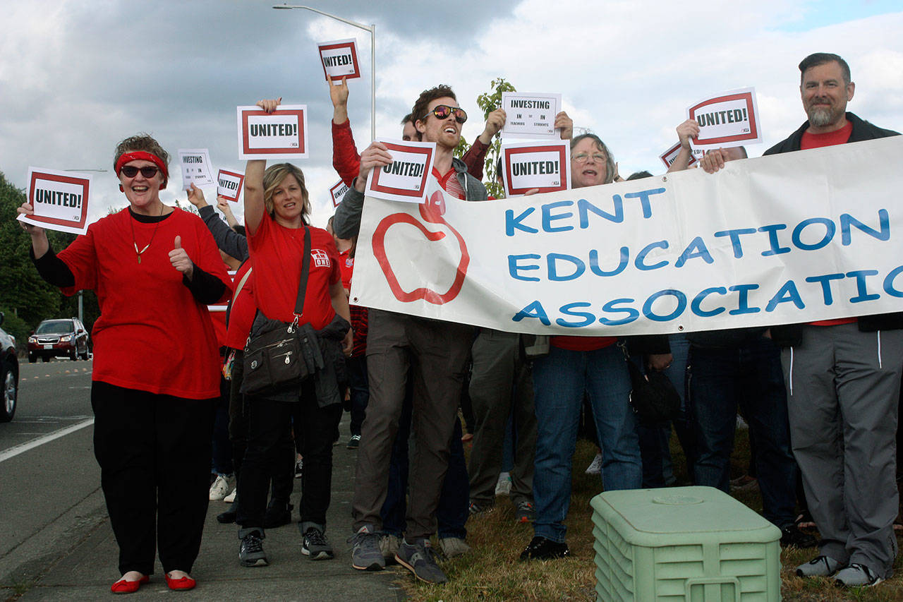 Union teachers rally in front of Valley View Christian Church on Wednesday, waving to motorists passing along Southeast 256th Street. Kent teachers gathered for a bargain rally and tail gate party prior to marching to the Kent School District Office to demand improved compensation. MARK KLAAS, Kent Reporter