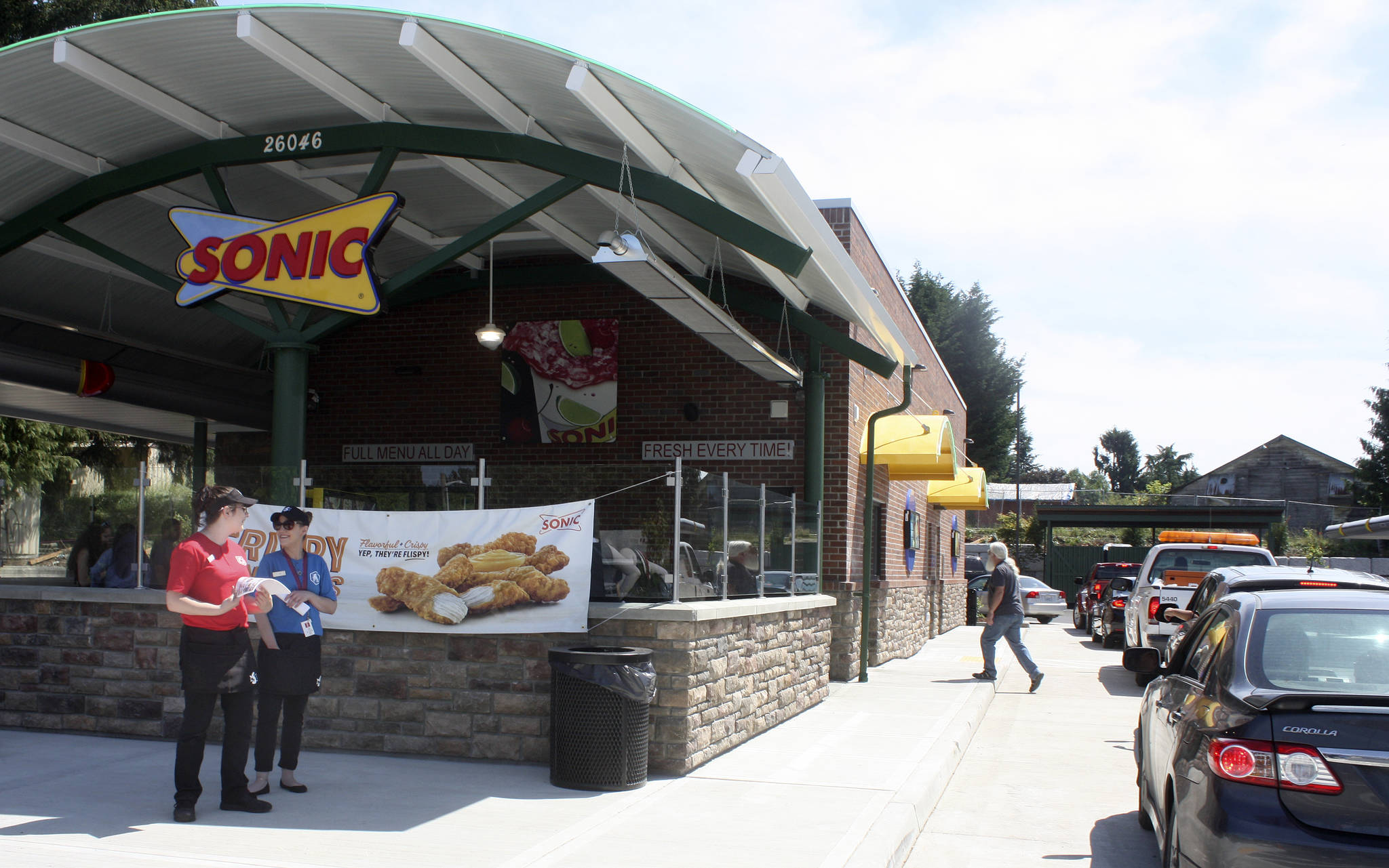 Sonic Drive-In employees Rachael Townsend, left, and Amy Hemstead stand ready as customers fill the drive-thru lane at Kent’s new Sonic restaurant on Monday. MARK KLAAS, Kent Reporter