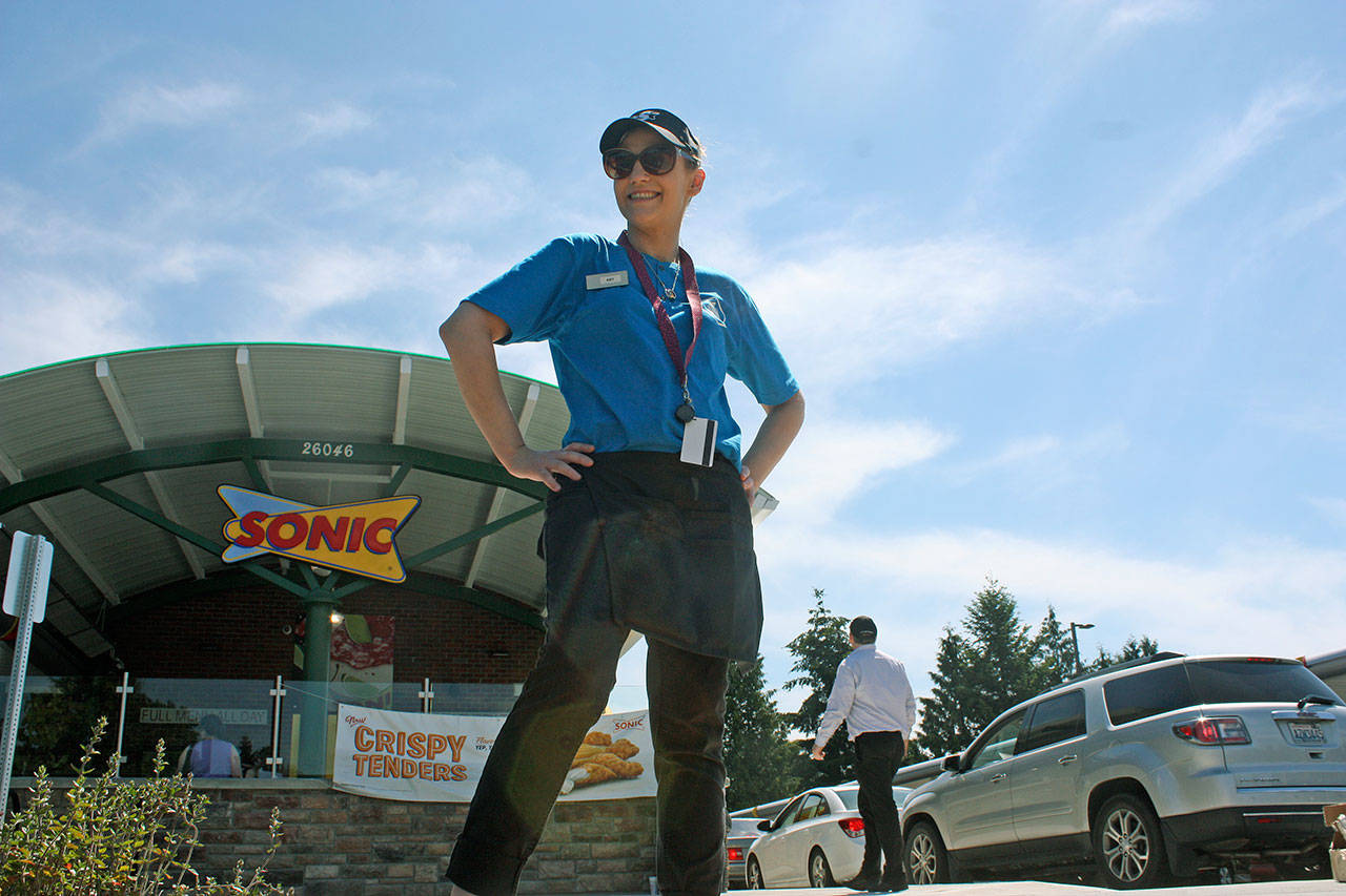 Sonic employee Amy Hemstead was busy welcoming customers through the drive-thru on Monday with a smile and opening-day coupons. MARK KLAAS, Kent Reporter
