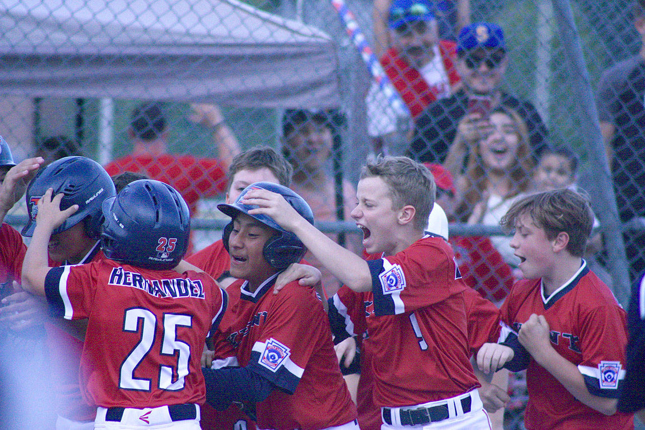 Kent All-Star teammates mob Patrick Sanchez, far left, after the shortstop hit a game-winning, walk-off home run against FME/Steel Lake in an elimination game Thursday at Sunset Park in Auburn. MARK KLAAS, Kent Reporter