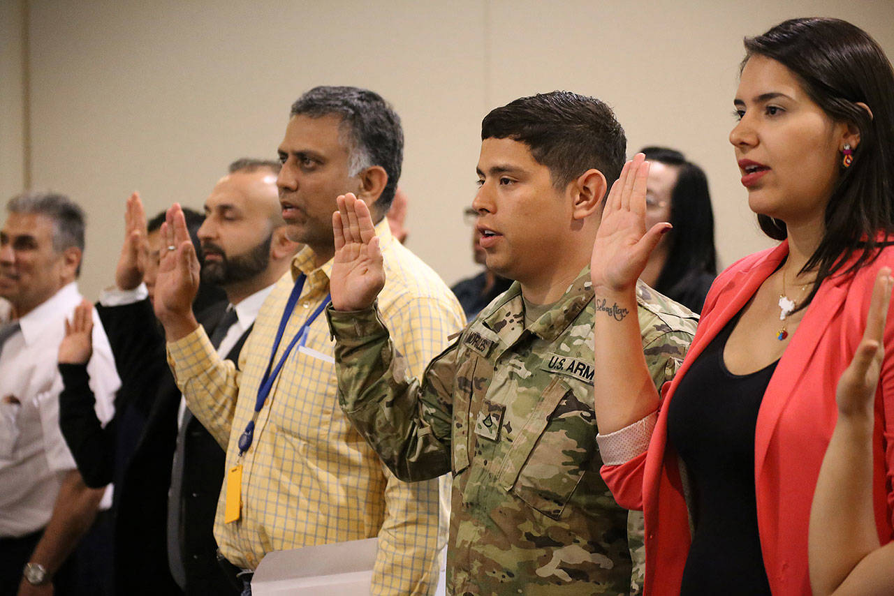 Pvt. 1st Class Aquiles R. Morales Centeno of Headquarters and Headquarters Company, 3rd Battalion, 161st Infantry Regiment, 81st Stryker Brigade Combat Team, recites the Naturalization Oath of Allegiance to the United States of America to become a naturalized citizen of the U.S. July 17 in Tukwila. Pfc. Morales is a native of Nicaragua but joined the Washington National Guard with the goal of earning his college degree. COURTESY PHOTO, U.S. Army National Guard, Sgt. 1st Class Jason Kriess.