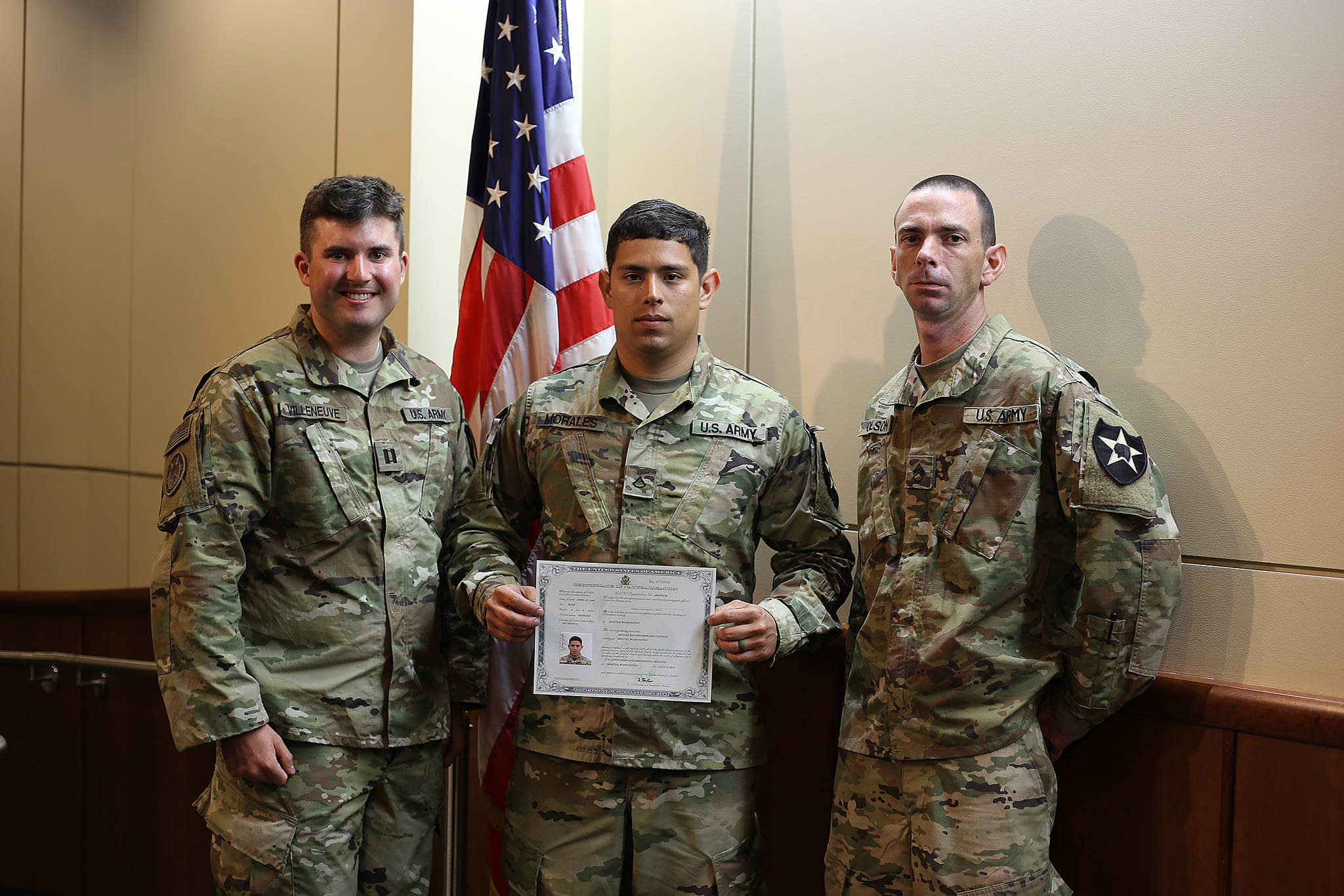 Pvt. 1st Class Aquiles R. Morales Centeno, center, of Headquarters and Headquarters Company, 3rd Battalion, 161st Infantry Regiment, 81st Stryker Brigade Combat Team, poses for a photo with his company commander, Capt. Jordan Villeneuve, left, and his section leader, Staff Sgt. Jeremiah Olson after reciting the Naturalization Oath of Allegiance to the United States of America to become a naturalized citizen of the U.S. July 17, 2018 in Tukwila. Pfc. Morales is a native of Nicaragua but joined the Washington National Guard with the goal of earning his college degree. COURTESY PHOTO, U.S. Army National Guard, Sgt. 1st Class Jason Kriess.