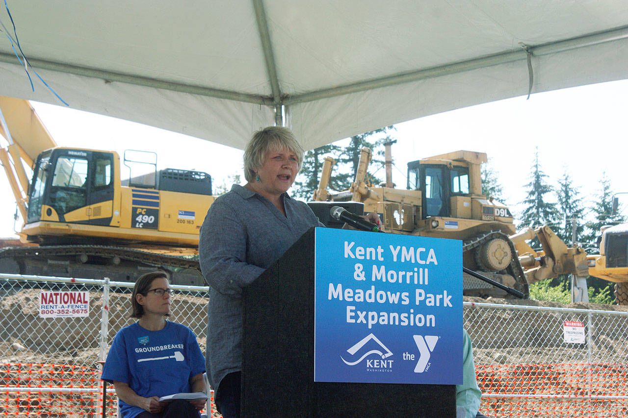 With idle, heavy machinery from Abbott Construction as a backdrop, Kent Mayor Dana Ralph addresses the crowd during at the YMCA groundbreaking ceremony at Morrill Meadows Park last Saturday. Waiting for her turn to speak is Katie O’Sullivan, board chair for the YMCA of Greater Seattle. MARK KLAAS, Kent Reporter