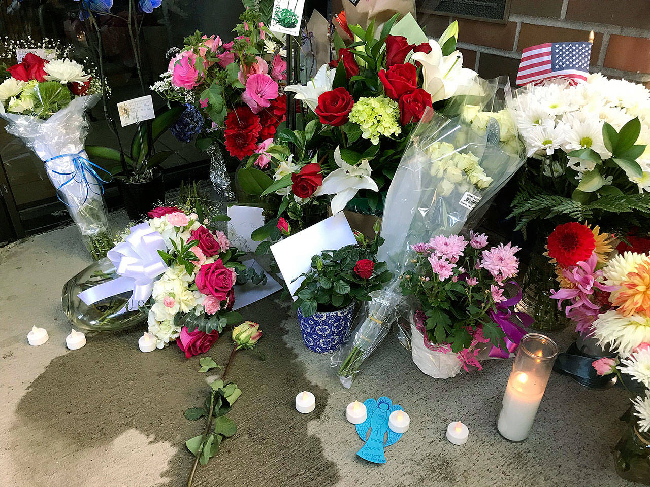 A memorial for a fallen Kent Police officer mounts outside the department’s headquarters Monday. Officer Diego Moreno, an eight-year veteran, was killed while helping police chase down suspects allegedly involved in a gunfire incident early Sunday morning. MARK KLAAS, Kent Reporter