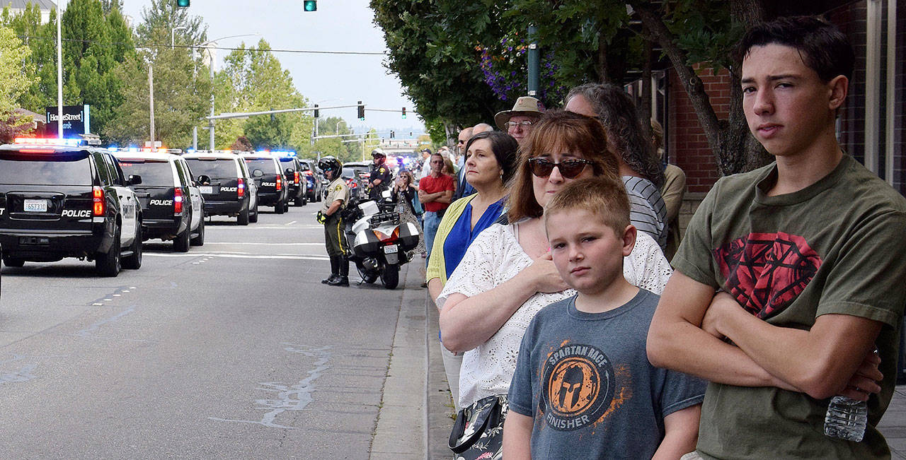 People line Fourth Avenue North as a procession for fallen Kent Police Officer Diego Moreno heads to the accesso ShoWare Center for a memorial service Tuesday. RACHEL CIAMPI, Reporter