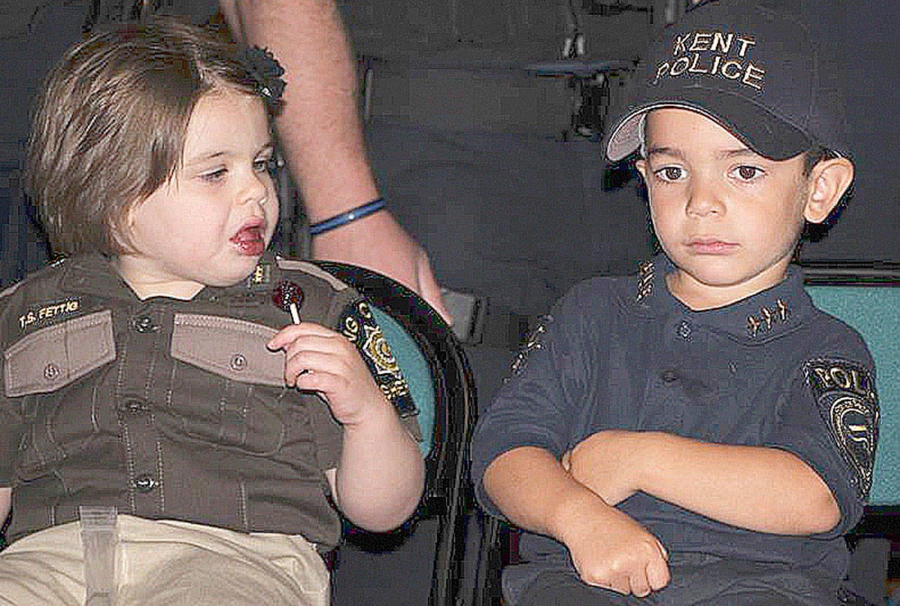 Syelis “Sye” Lee Wakeman, 4, of Kent, right, serves as the Kent Police Chief for a Day. Wakeman takes a break during the Aug. 16 ceremony in Burien along with the King County Sheriff’s Office Sheriff for a Day. COURTESY PHOTO, Kent Police