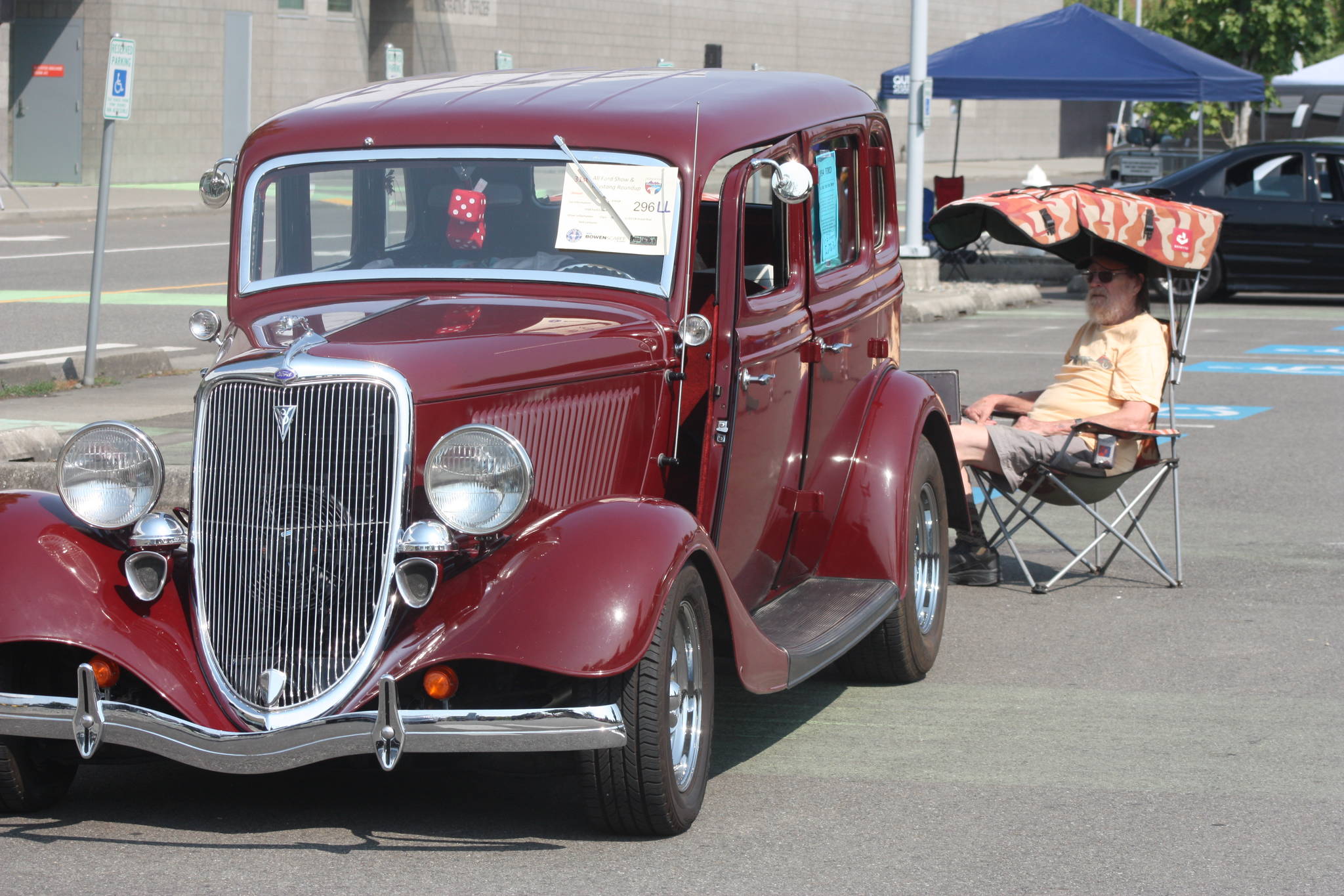 Neil Lemaster watches as his 1934 Ford Coupe, which he drove to the show from Mercer Island, glimmers in the sun last Saturday. MARK KLAAS, Kent Reporter