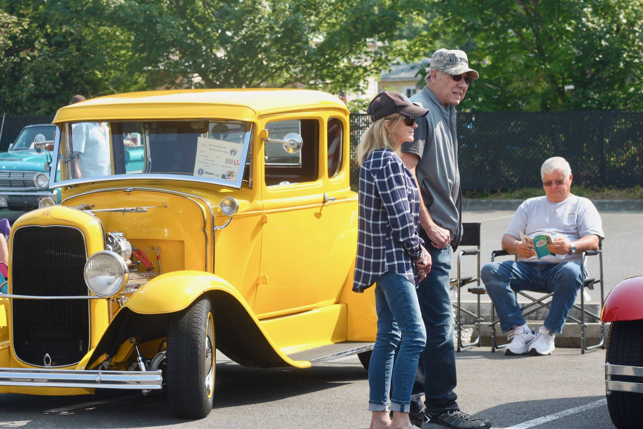 Jim Davitk, owner of a yellow 1930 Ford Model A street rod, sits quietly, as onlookers take in the classic cars. MARK KLAAS, Kent Reporter