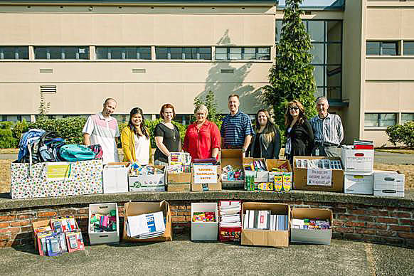 Mayor Dana Ralph joins city employees in delivering school supplies at Kent-Meridian High School on Tuesday. COURTESY PHOTO
