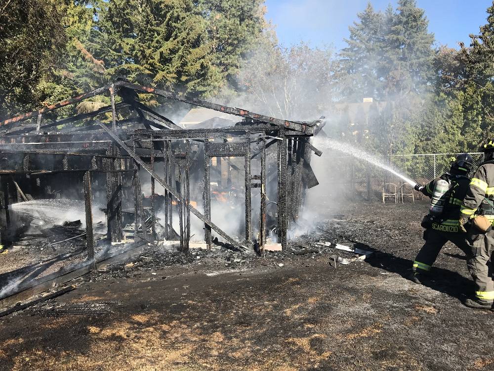 Firefighters mop up after dousing a detached garage fire in Kent on Sunday. No one was hurt in the fire. COURTESY PHOTO, Puget Sound RFA