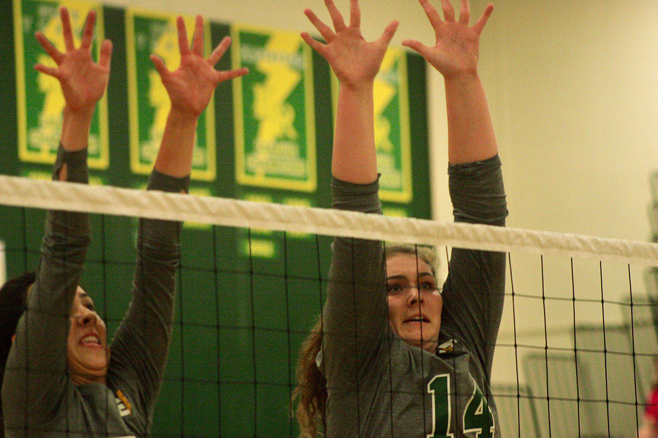 Kentridge’s Madeline Gooding, right, and a teammate reach to block a shot during the Chargers’ sweep of Kentlake in a North Puget Sound League Cascade Division match Thursday night. MARK KLAAS, Kent Reporter