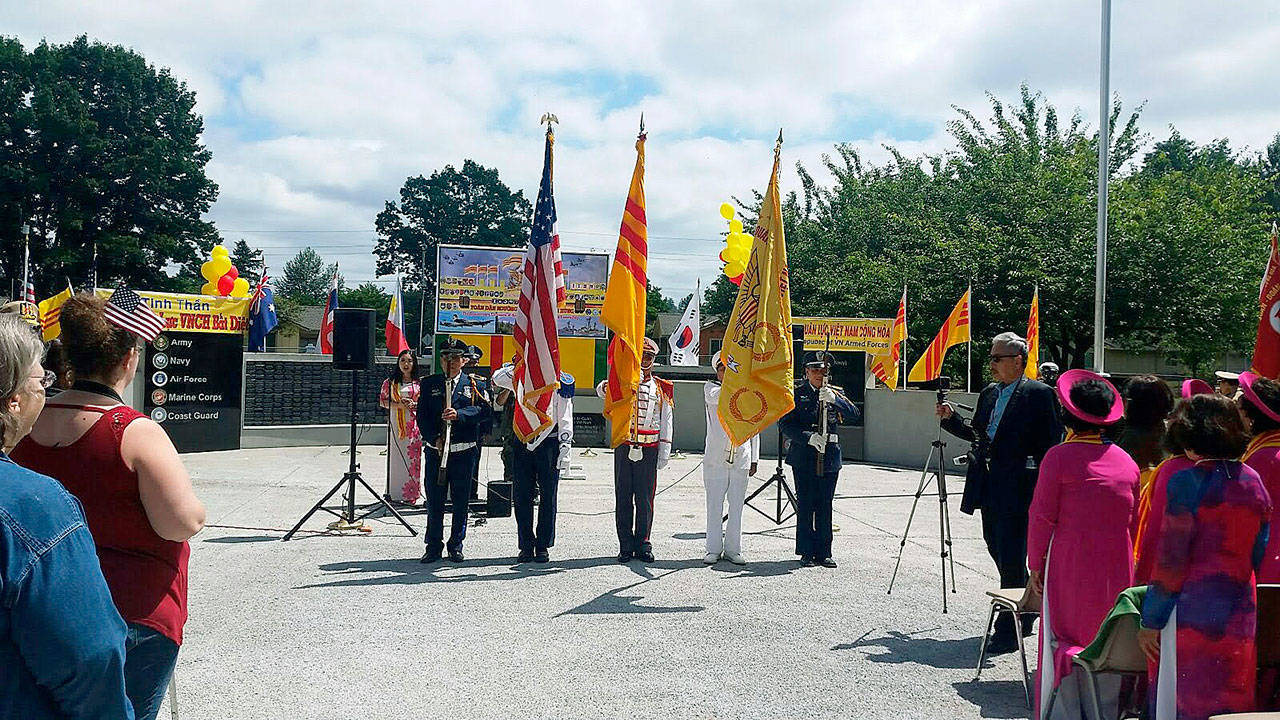 Flags of the two nations that fought side-by-side in the Vietnam War look down upon the dedication of the joint American-Vietnamese Memorial at Les Gove Park on June 16. ROBERT WHALE, Auburn Reporter