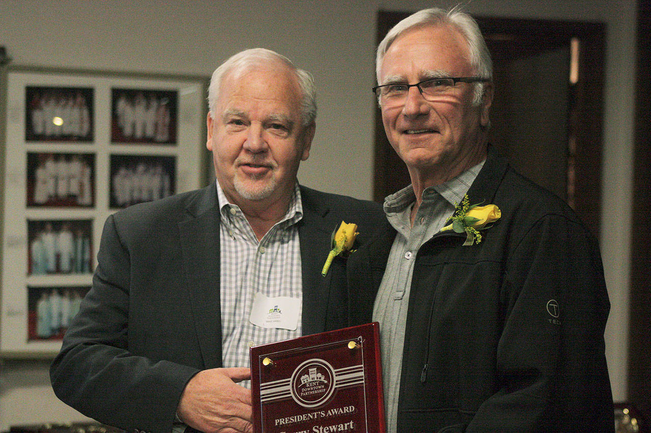 Mike Hanis, Kent Downtown Partnership president, left, presents the KDP President’s Award to Garry Stewart, operator of The Doorman Service Company, Inc., during Wednesday’s program. MARK KLAAS, Kent Reporter