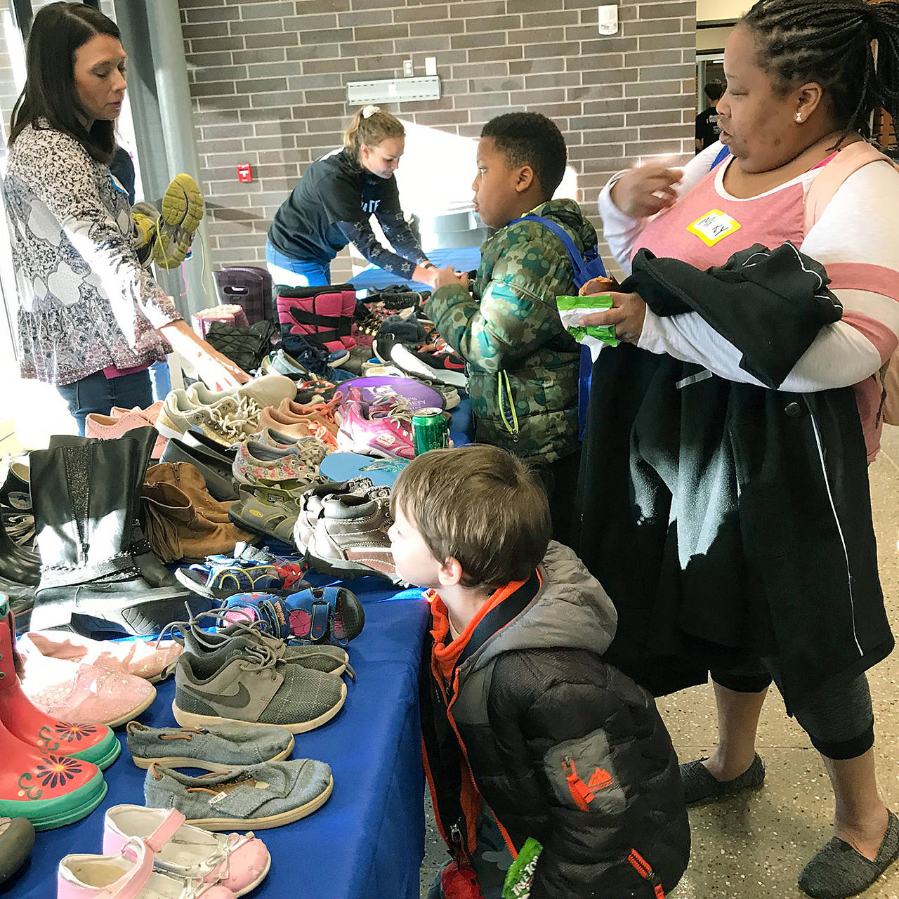 Families shop for shoes, courtesy of Redeeming Soles, during the United Way of King County’s Family Resource Exchange at Green River College last Saturday. MARK KLAAS, Auburn Reporter