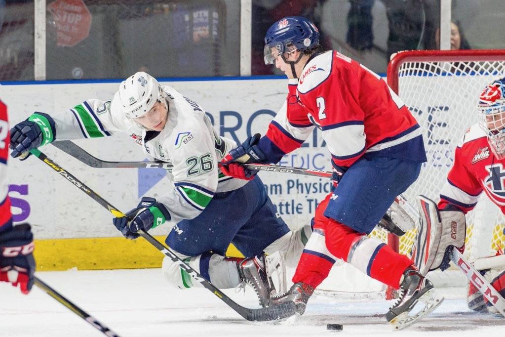 The Thunderbirds’ Nolan Volcan tries to move the puck in front of Hurricanes defenseman Calen Addison and Lethbridge keeper Carl Tetachuk during WHL play Friday night at the accesso ShoWare Center. COURTESY PHOTO, Brian Liesse/T-Birds