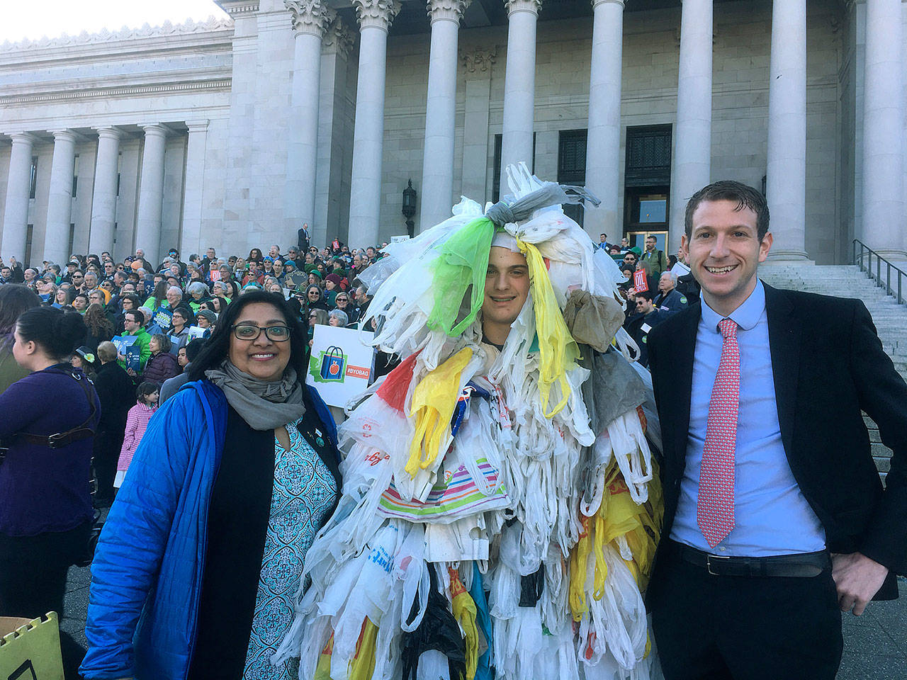 Sen. Mona Das and Rep. Joe Fitzgibbon with the “Bag Monster” on the steps of the Capitol Building in Olympia. COURTESY PHOTO