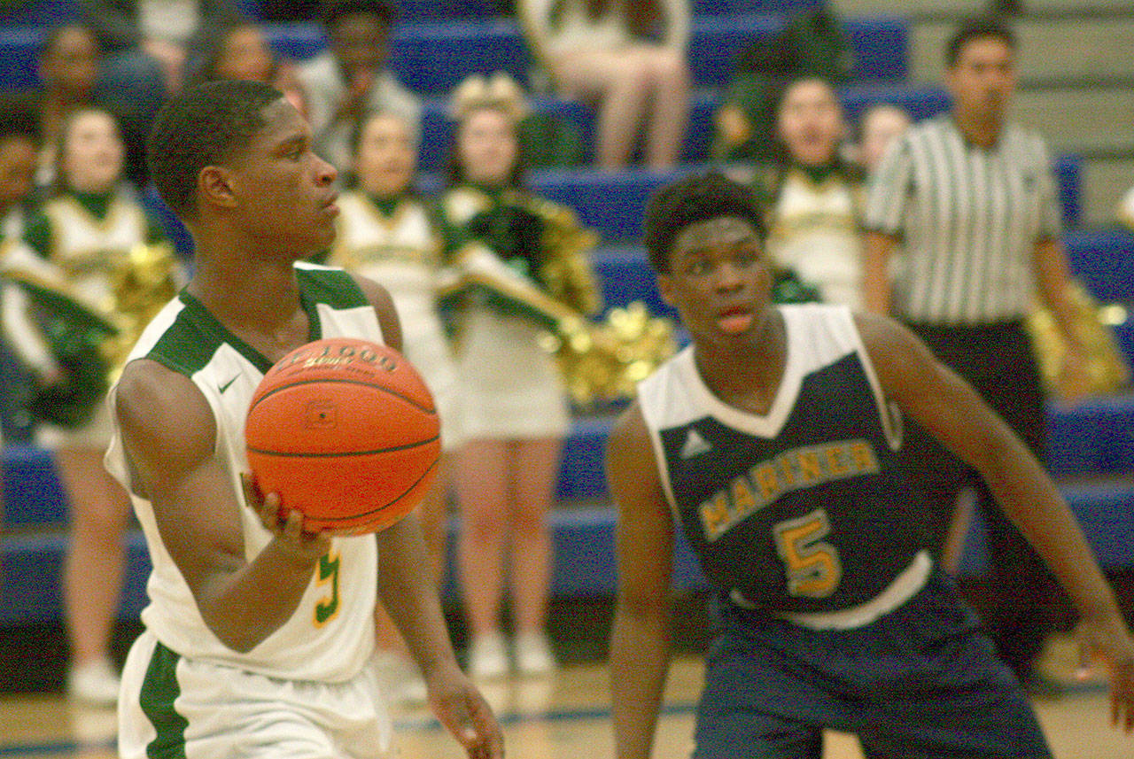 Kentridge’s Jeremy Banks looks to pass inside as Mariner’s Edwin Bouah defends during 4A regional boys basketball playoff action at Auburn Mountainview High School on Saturday night. Banks’ all-around game lifted the Chargers to a state-qualifying win. MARK KLAAS, Kent Reporter