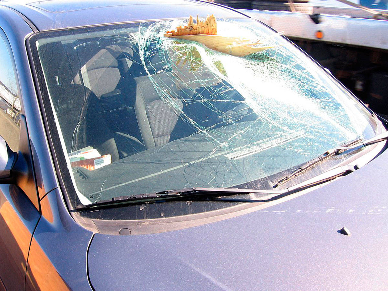 A driver suffered only minor scratches from glass splinters after a piece of lumber from an unsecured load went through the vehicle’s windshield around noon Tuesday along Highway 167 southbound in Kent near the 84th Avenue South exit. The driver of the vehicle that lost the lumber did not stop. COURTESY PHOTO, State Patrol