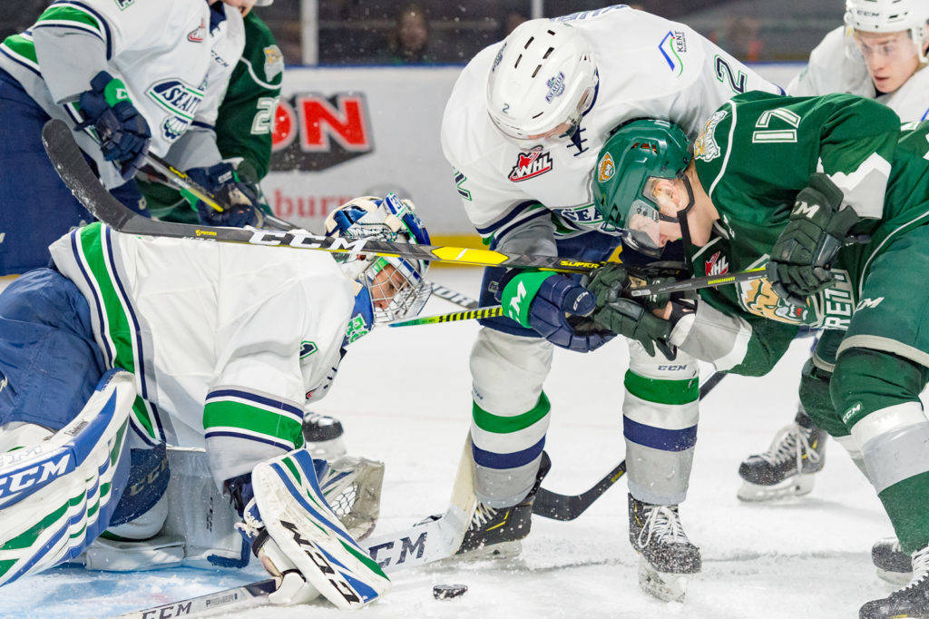 Thunderbirds defenseman Simon Kubicek (2) and the Silvertips’ Jackson Berezowski (17) battle for position as Seattle goalie Roddy Ross prepares to smother the puck during WHL play Saturday night. COURTESY PHOTO, Brian Liesse, T-Birds