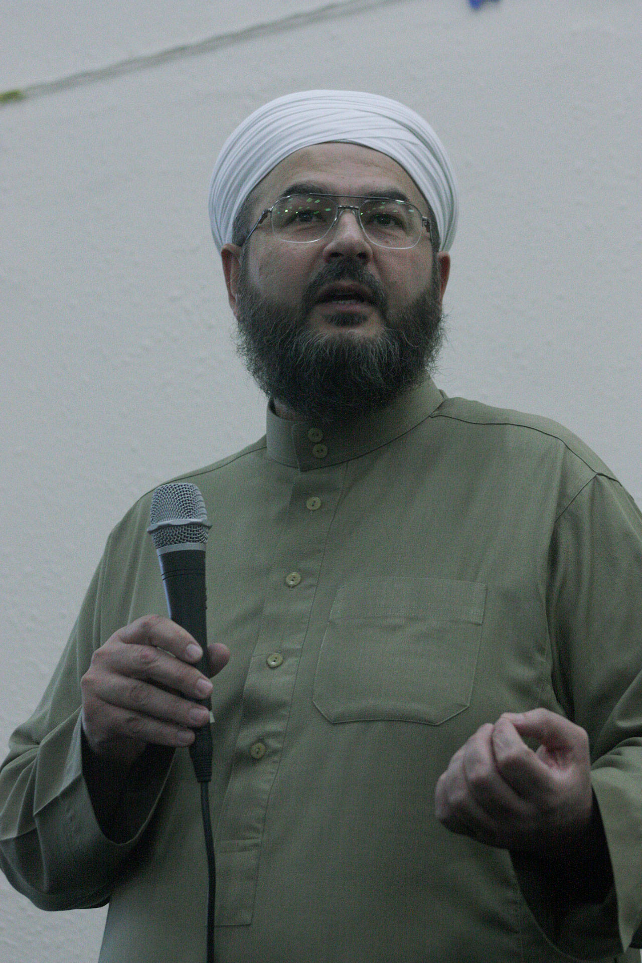 Shaykh Imad Al Busaad, imam of the Kent Islamic Center, speaks at a joint interfaith vigil and community gathering at the center’s gym Friday night. Al Busaad urged people of all faiths to come together and strive for peace in an era of Islamophobia. MARK KLAAS, Kent Reporter