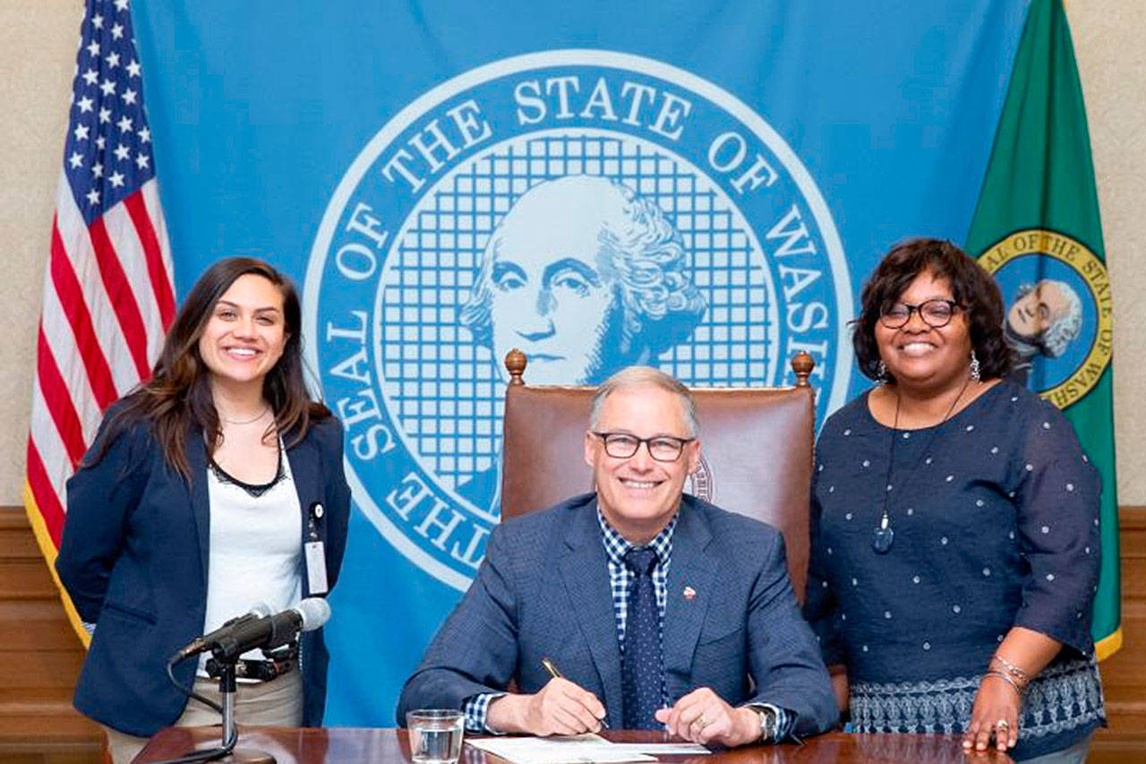 Rep. Debra Entenman, D-Kent, right, with her legislative assistant, Simrun Chhabra, left, and Gov. Jay Inslee at bill signing in Olympia to crack down on sex traffickers who attempt to circumvent no-contact orders. COURTESY PHOTO