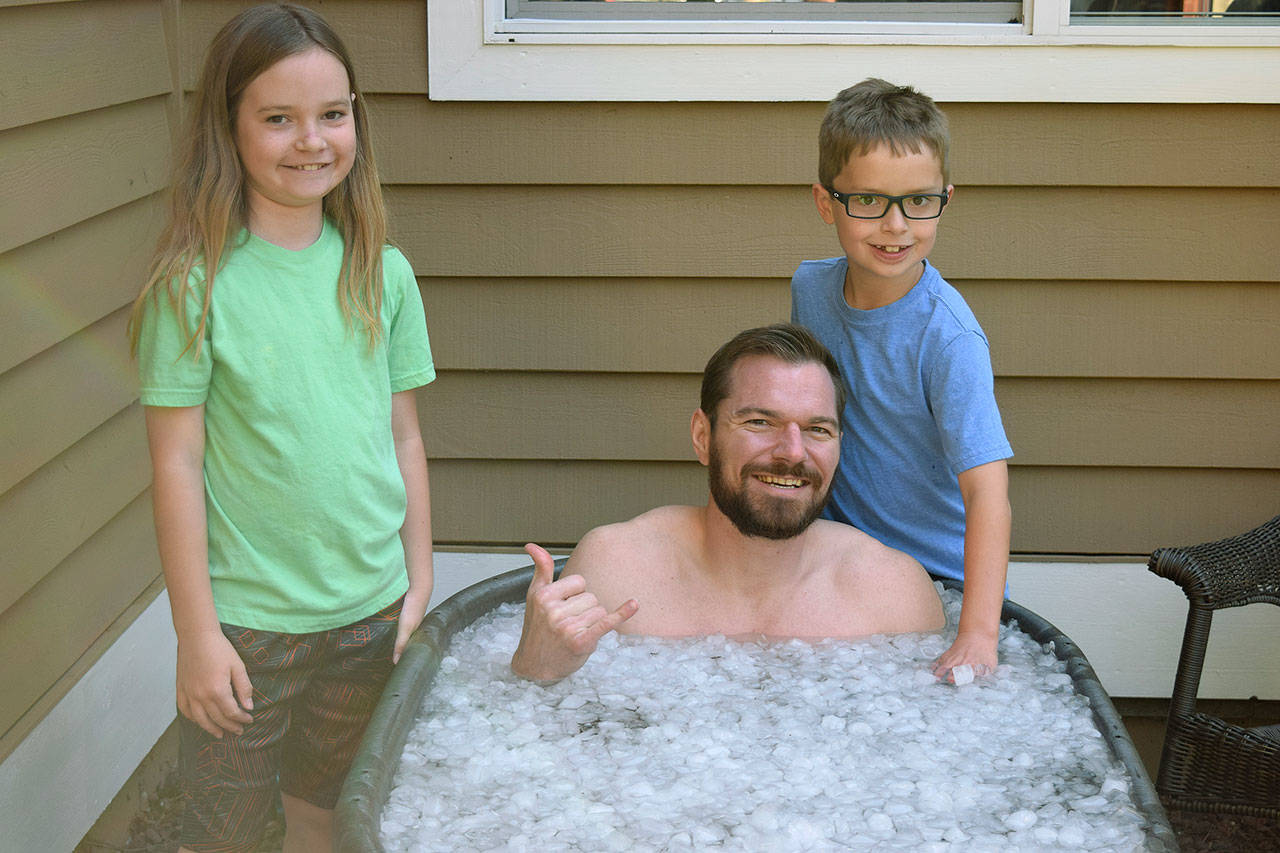 Justin Gielski, an “American Ninja Warrior” contestant, sits in an ice bath after a workout. With him are his two children, Sophie, 9, and Axel 8. COURTESY PHOTO