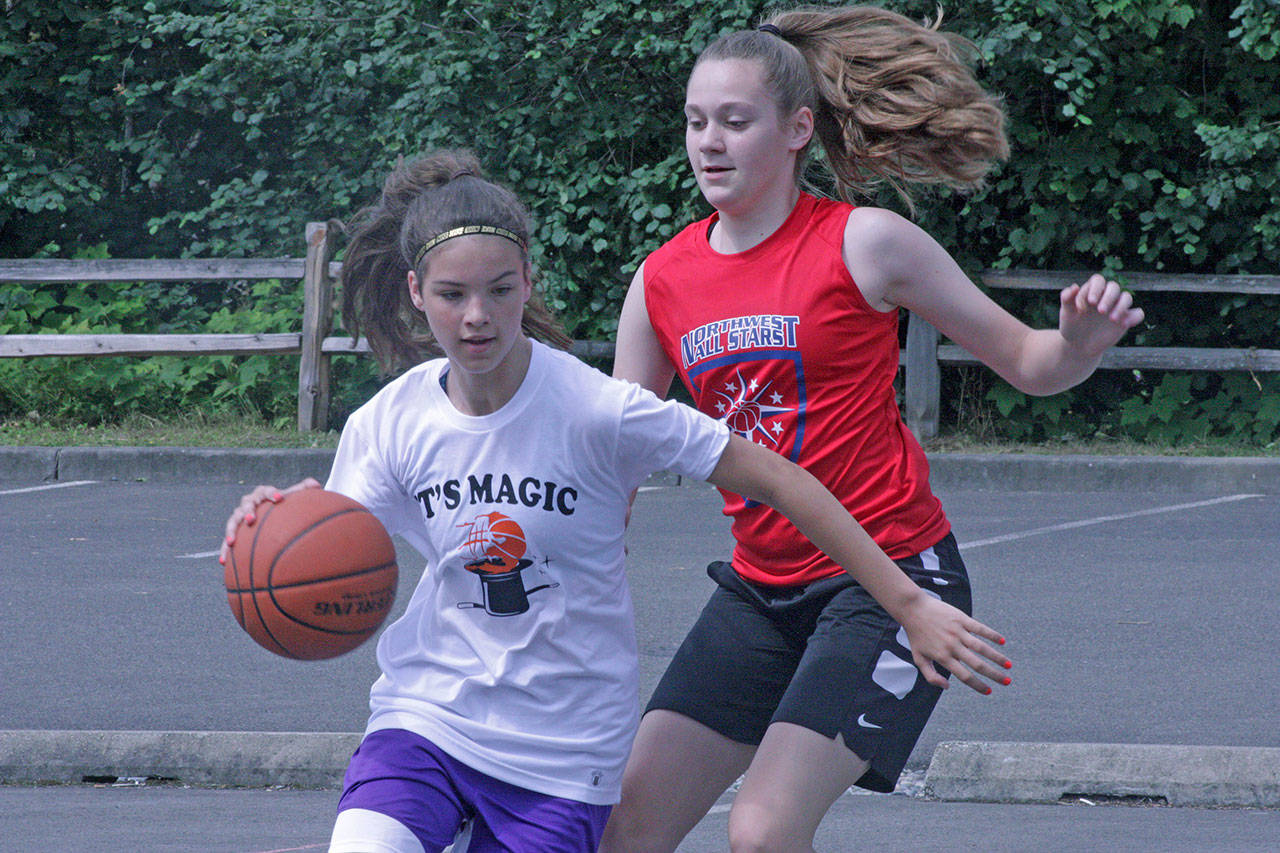 Bo Young, of Team Do You Believe in Magic, dribbles away from the Northwest All-Stars’ Bella Firnkoess during eighth-grade division play at the ShoWare Shootout last Saturday. MARK KLAAS, Kent Reporter