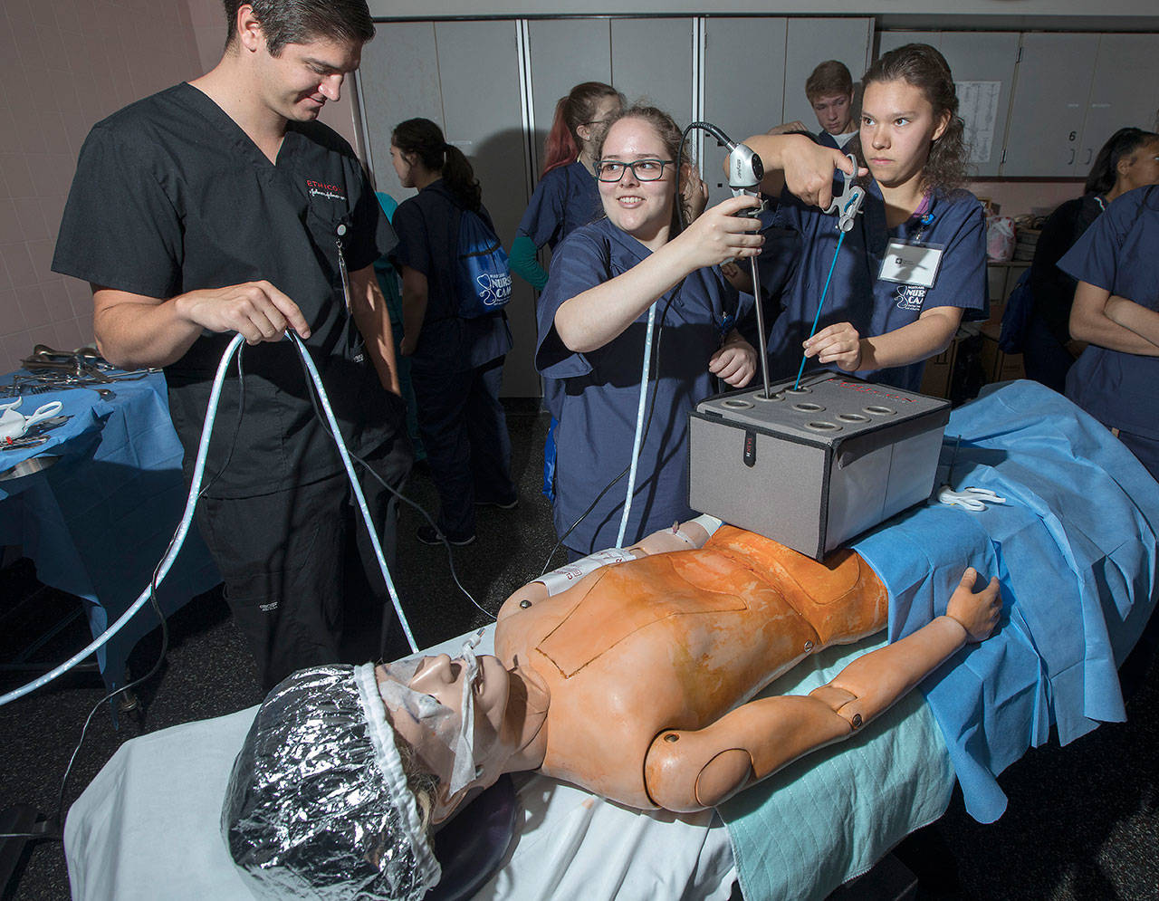 Erika Reinhardt, of Kent, middle, practices her laparoscopic surgery skills July, 17 during MultiCare’s annual Nurse Camp at Tacoma General Hospital. COURTESY PHOTO, Patrick Hagerty