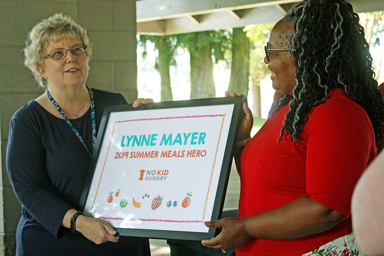 State Rep. Debra Entenman, D-Covington, right, presents the No Kid Hungry’s 2019 Summer Meals Hero award to Kent School District’s Lynne Mayer during an impromptu ceremony Thursday at Lake Meridian Park. MARK KLAAS, Kent Reporter