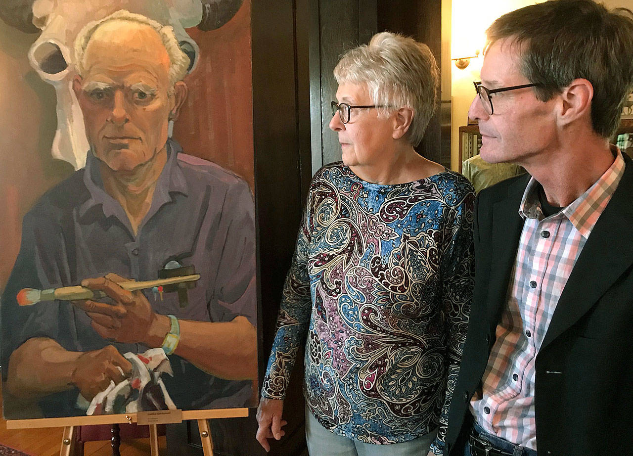Kent Historical Museum’s Nancy Simpson and Stephen Chandler glance at Danny Pierce’s self-portrait painting at his exhibit in the Bereiter House. The museum’s display devoted to the late, great Kent artist is open to the public through Oct. 5. MARK KLAAS, Kent Reporter