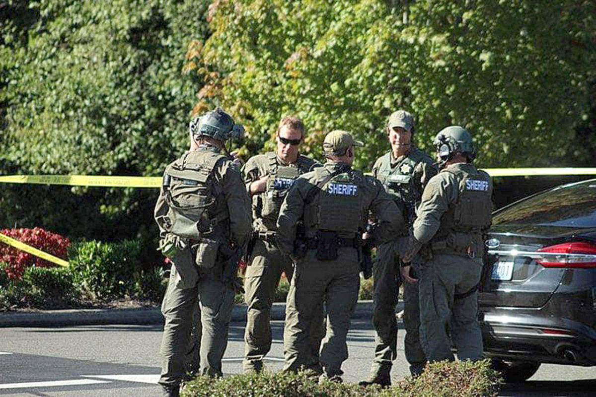 King County Sheriff’s Office detectives and SWAT team members debrief at the scene of an officer-involved shooting on Wednesday afternoon in Federal Way. OLIVIA SULLIVAN, Federal Way Mirror