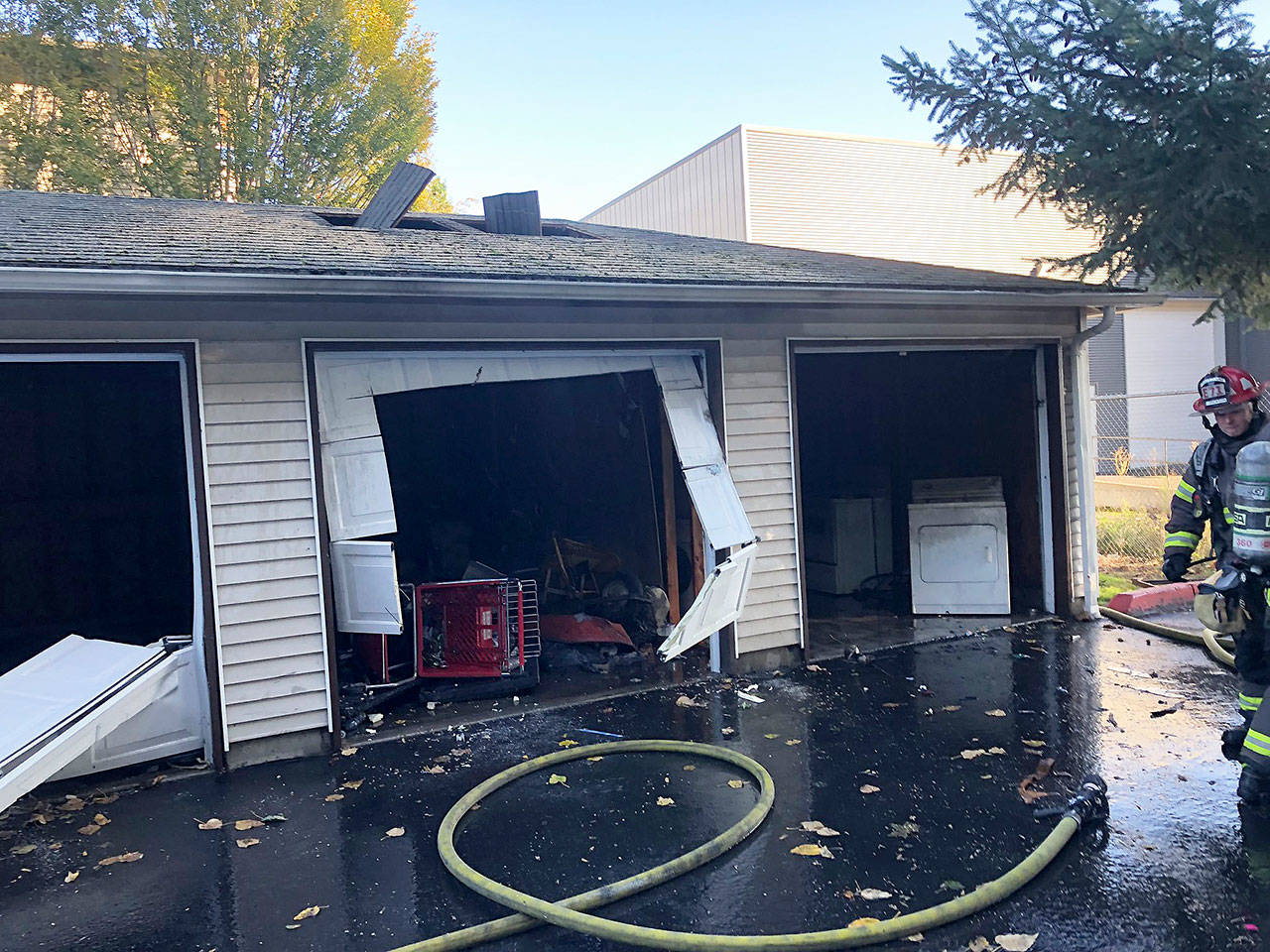 Puget Sound RFA firefighters put out a fire at a garage Wednesday at the Alderbrooke Apartments in Kent. COURTESY PHOTO, Puget Sound Fire