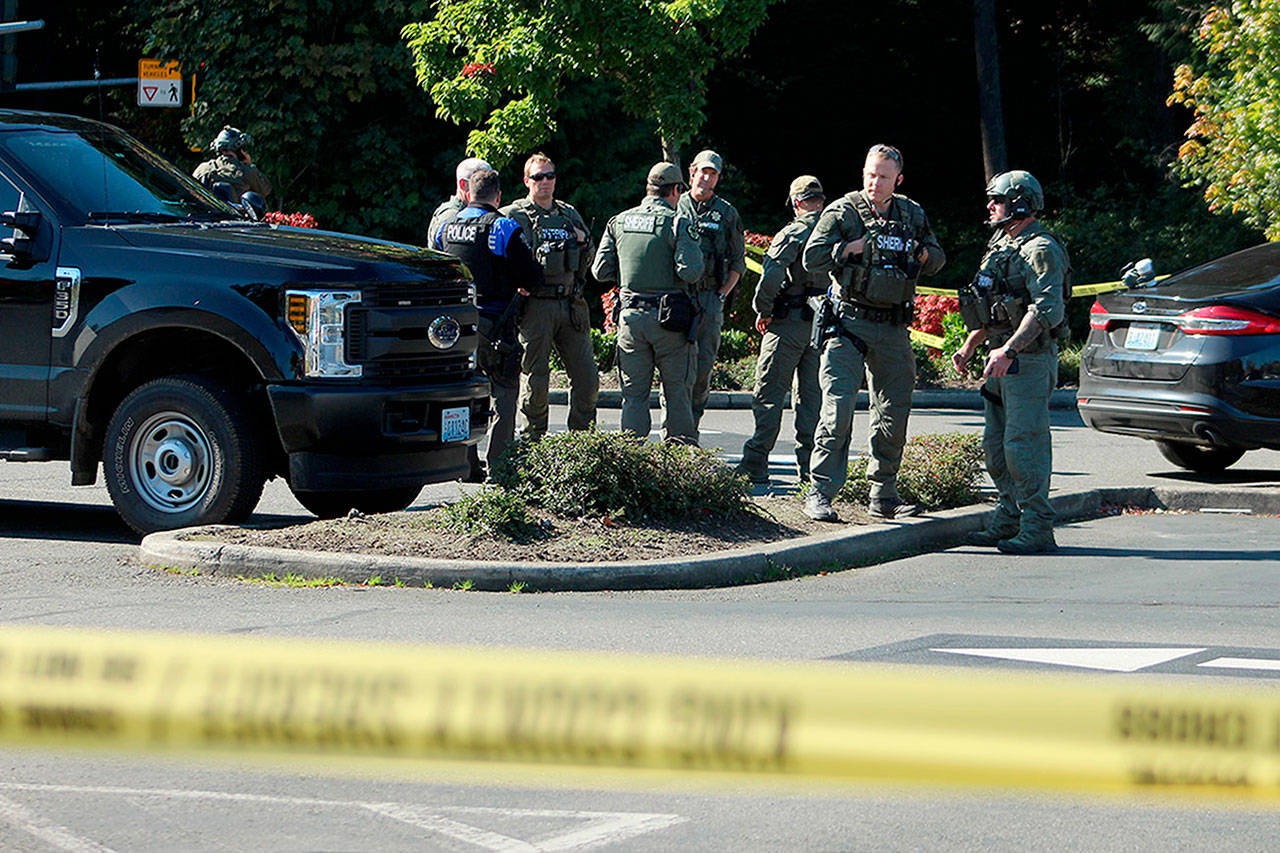 King County Sheriff’s Office detectives and SWAT team members debrief at the scene of an officer-involved shooting on Wednesday afternoon in Federal Way. OLIVIA SULLIVAN, Federal Way Mirror