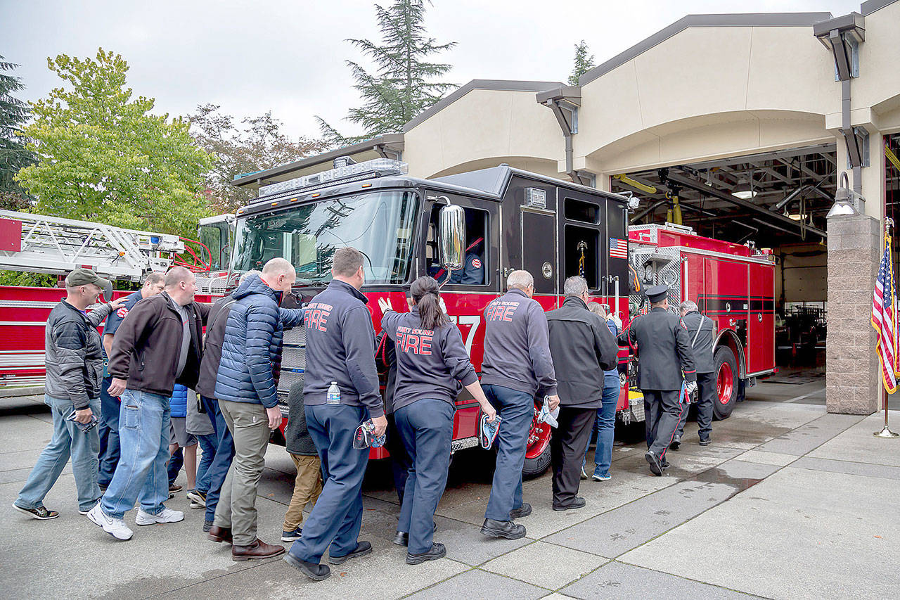 Puget Sound Fire personnel push a new engine into Station 77 in Kent as part of a tradition for new engines. Engine 77 went into service last month. COURTESY PHOTO, Puget Sound Fire