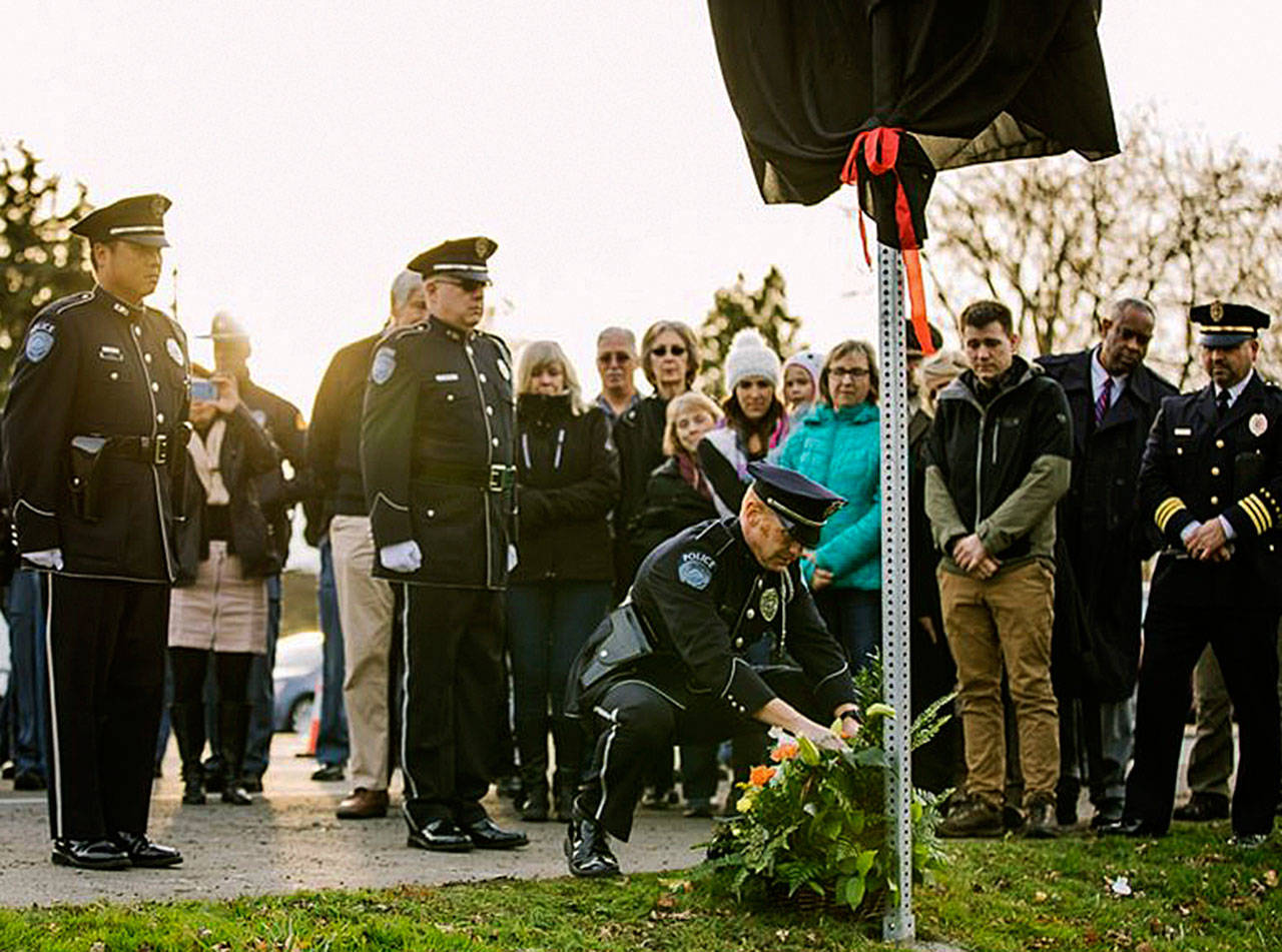 Kent Police, State Patrol troopers and others gather Nov. 26 to dedicate a memorial sign along Willis Street to Mike Buckingham, who led efforts to combat drunk driving in Kent for many years. COURTESY PHOTO, Kent Police