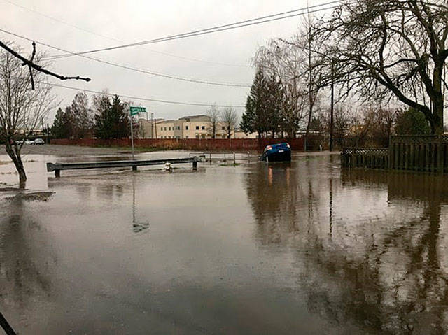 A car goes into the water Dec. 20 during Mill Creek flooding from heavy rain at Kennebeck Avenue North and East Temperance Street. COURTESY PHOTO, City of Kent