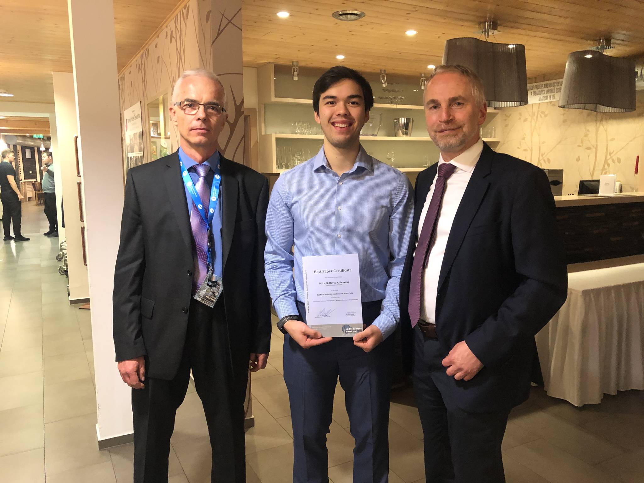 Dr. Joseph Foldyn, left, director of the Institute of Geonics of the Czech Academy of Sciences in Ostrava, Czech Republic, presented the Best Paper certificate to Michael Lo, middle, and Dr. Axel Henning, right of OMAX Corporation. COURTESY PHOTO