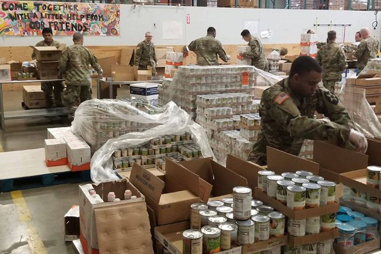 Members of the National Guard pack food boxes on Monday at the Northwest Harvest warehouse in Kent for distribution to food banks. COURTESY PHOTO, Northwest Harvest