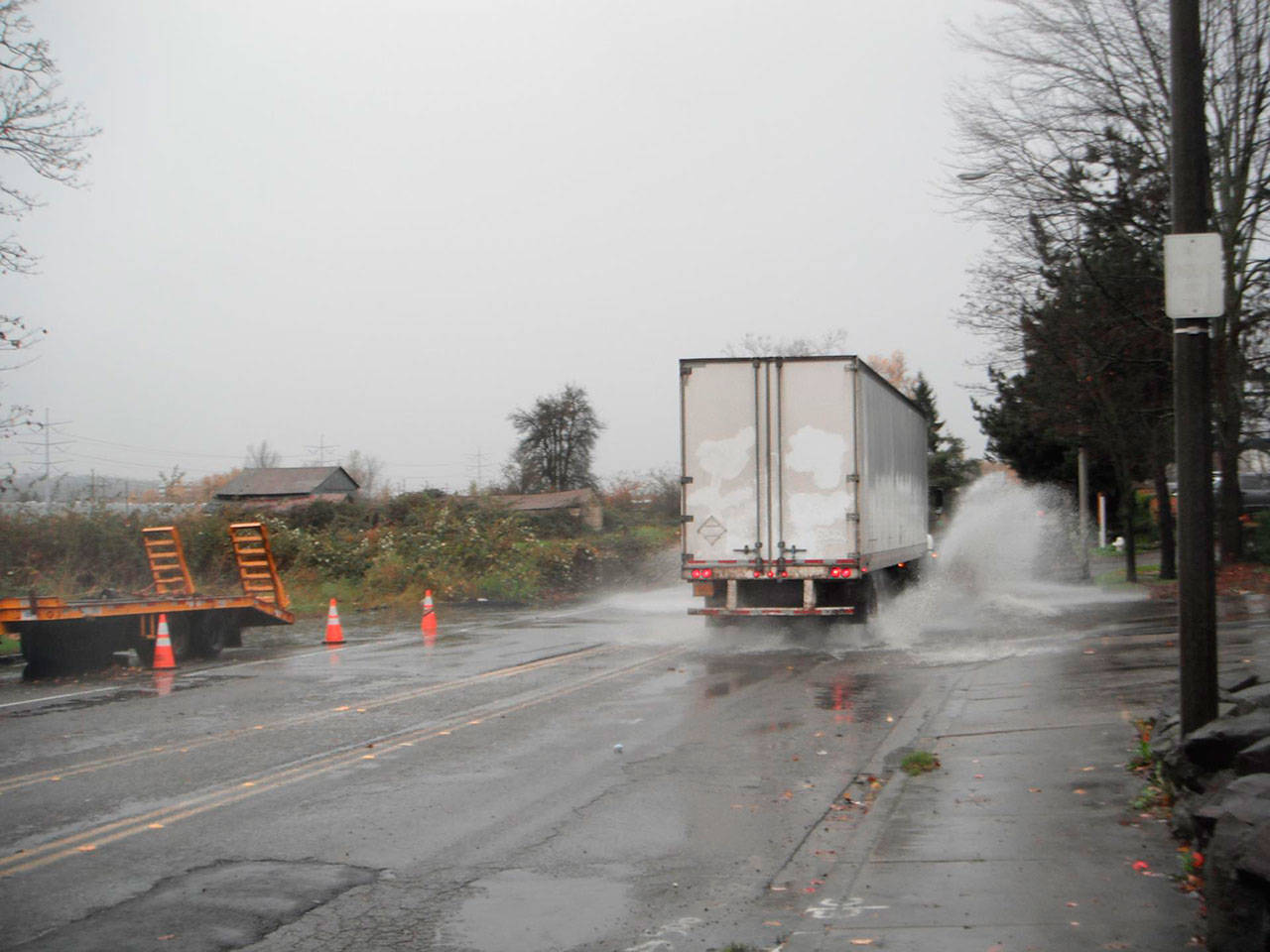 A truck travels through a flooded 76th Avenue South in Kent. A project this year will raise the road so it doesn’t flood anymore. COURTESY PHOTO, City of Kent