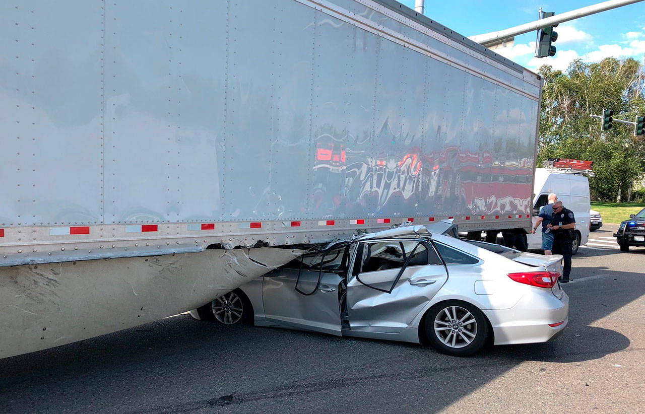 A car driver reportedly ran a red light and ends up under a UPS semi trailer Monday afternoon at the intersection of South 228th Street and 64th Avenue South in Kent. The driver suffered non-life threatening injuries. COURTESY PHOTO, Puget Sound Fire